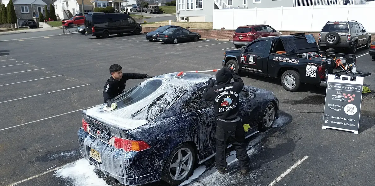 JH team foam washing a car beside the JH service truck